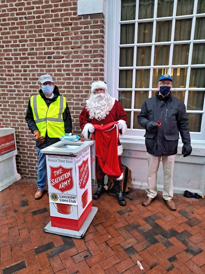 Christmas Santa and two men standing at salvation army box