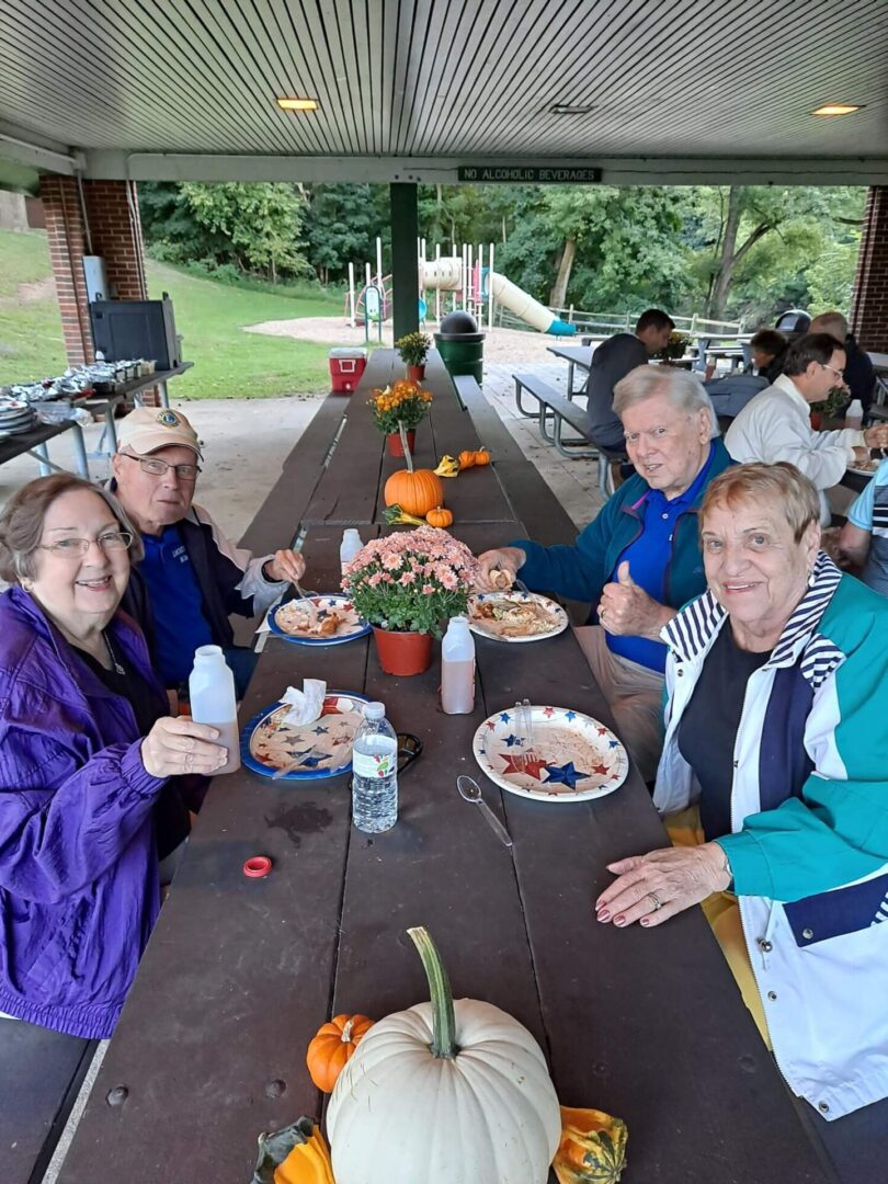 A Group of Elderly People Eating by Picnic Tables
