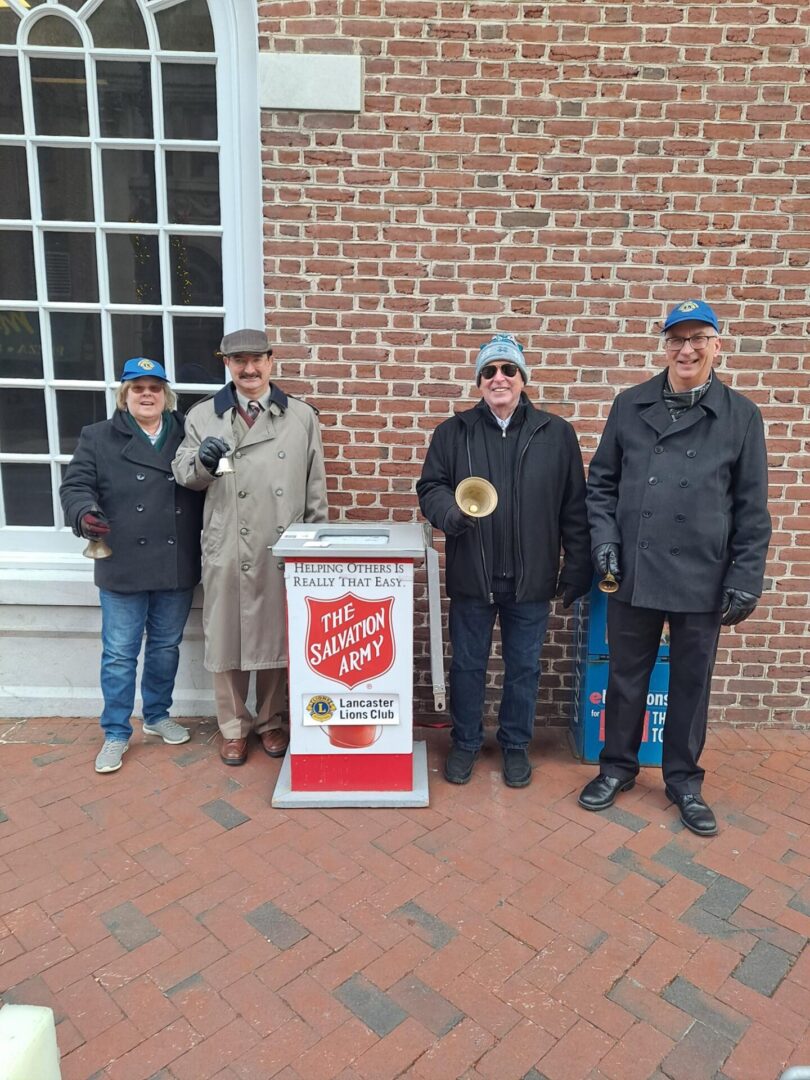 Four people standing at the salvation army box