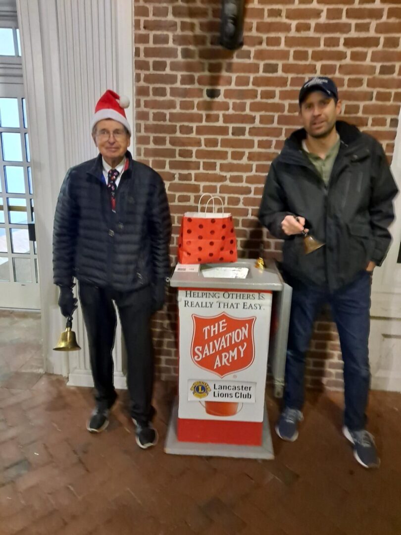 Two people standing beside the salvation army container